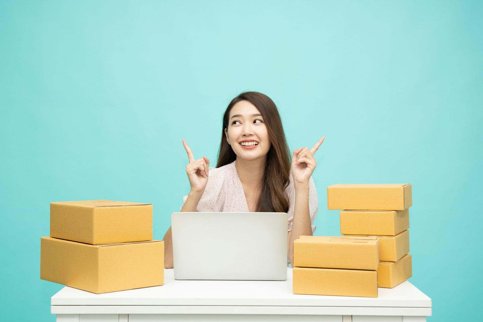 A small online store owner at her desk with shipping boxes and a laptop