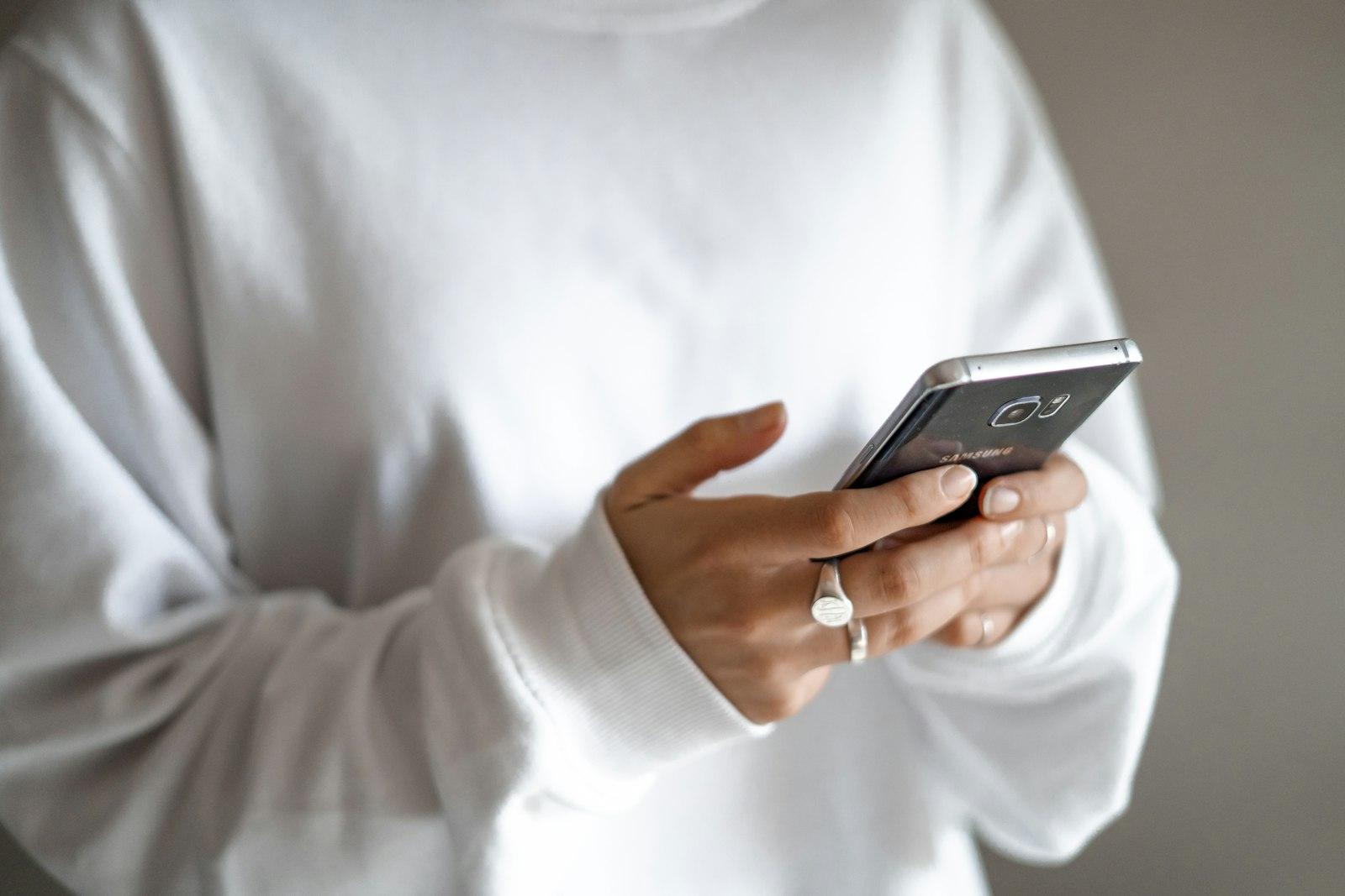 Close-up of hands holding and texting on a smartphone